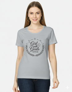 Woman wearing a gray t-shirt with 'Girl with Goals' text design on a white background